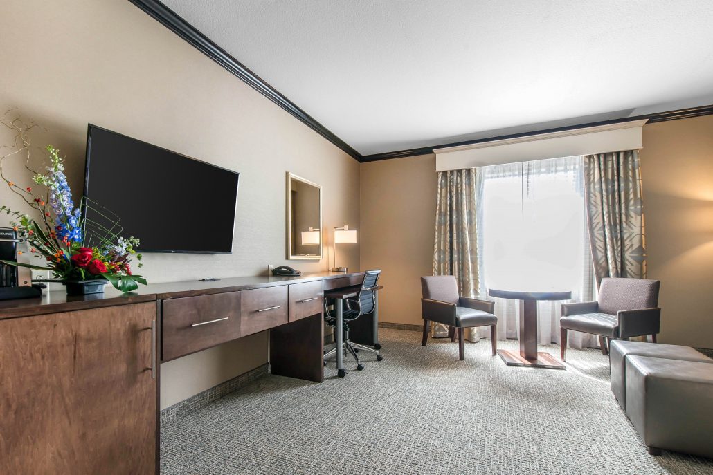 Heritage Inn & Suites room with tv, desk, and seating area