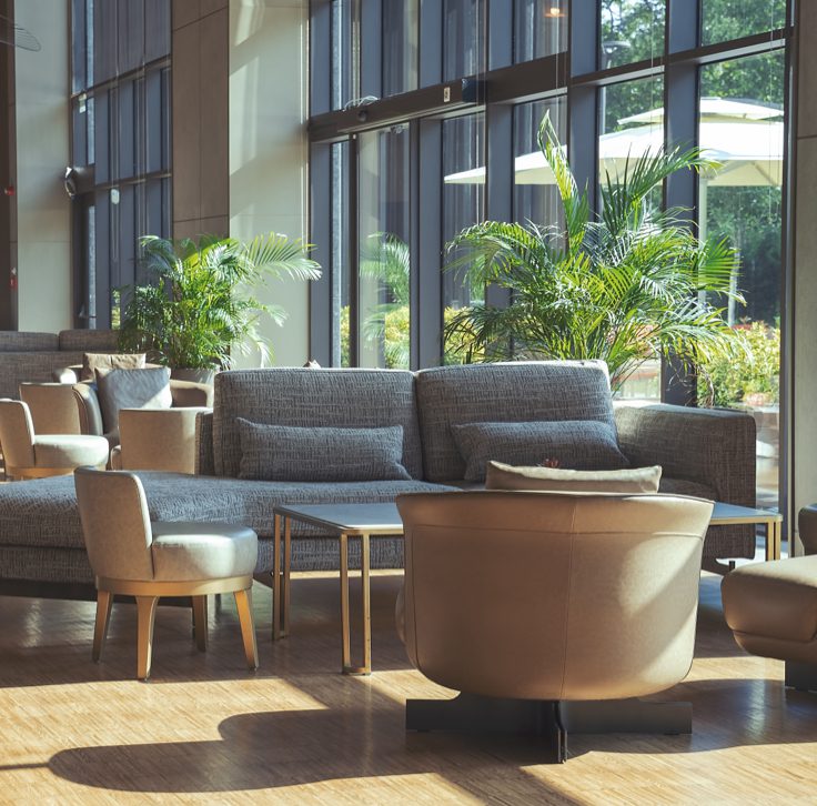 hotel lobby area with seating area, floor to ceiling windows, and indoor plans