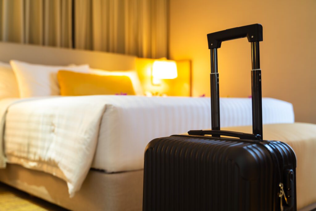 Suitcase sitting in front of a bed in a hotel room
