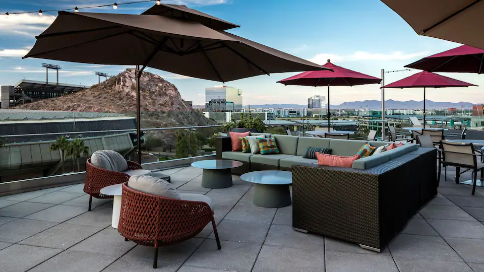 Hyatt House rooftop patio with seating and a view of a city