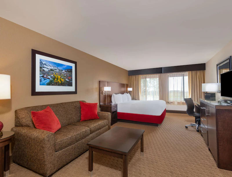 Raddison hotel room with red accent color, bed and couch