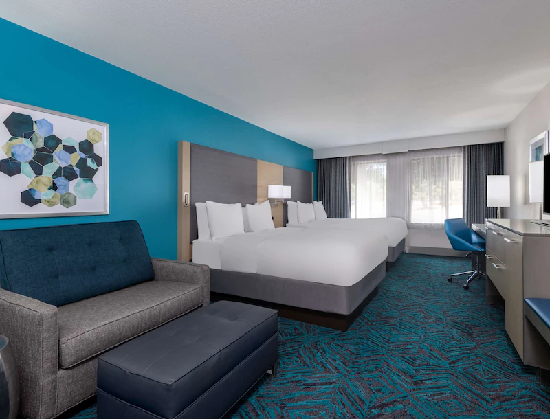 Hotel room with decorative blue and black carpet and two queen size beds