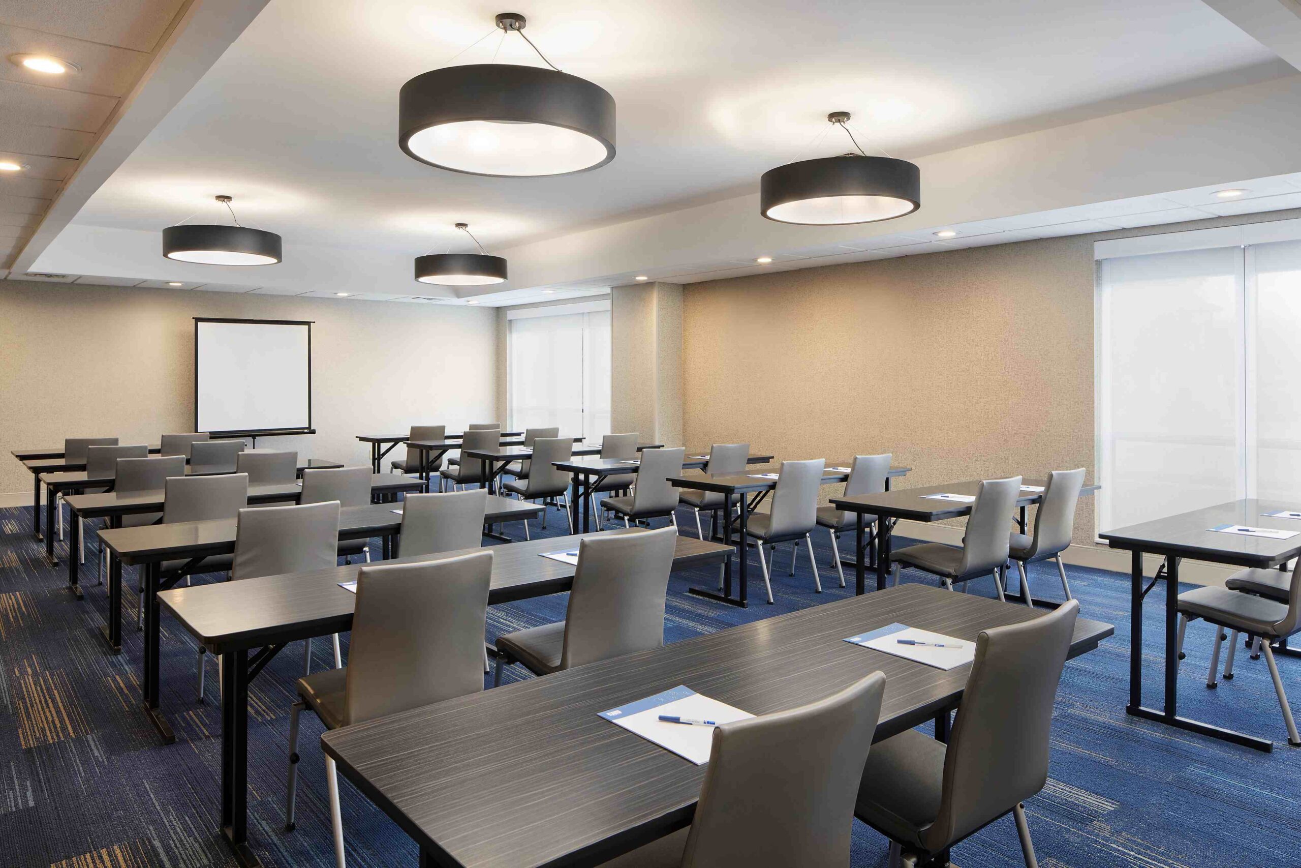 Conference Room with a projector screen, desks, and chairs